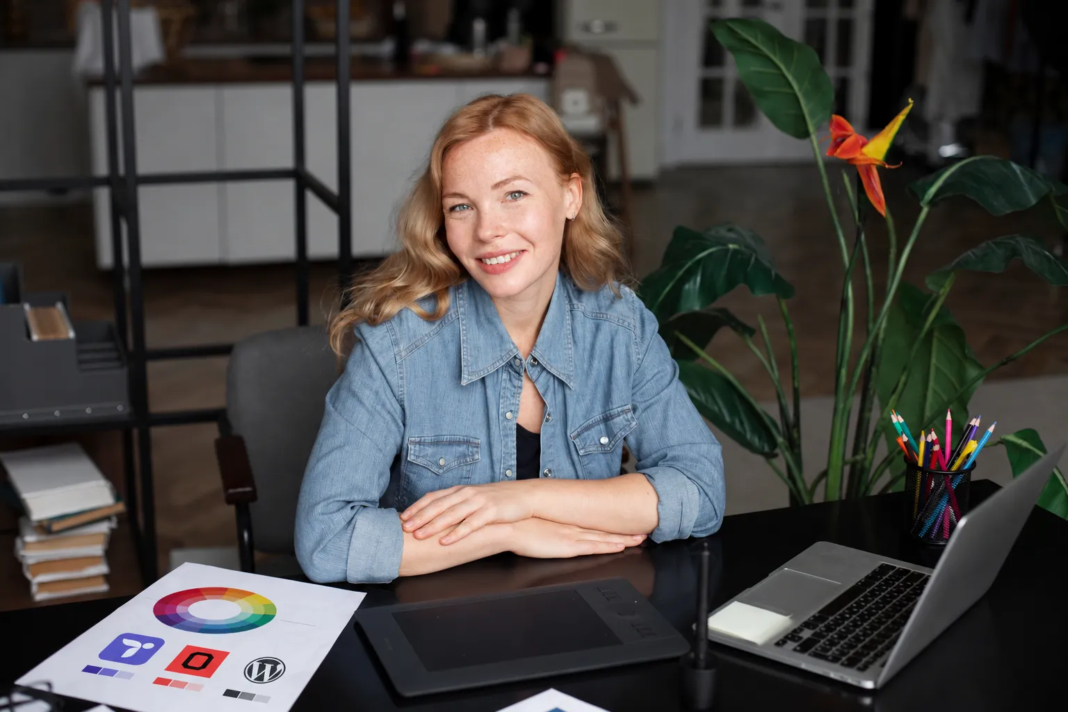 A web designer working on a laptop with a Themeasy sticker, at a café table